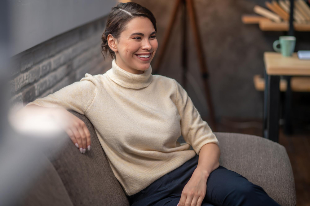 Happy woman sitting on a couch during an intensive outpatient program near Atlanta.