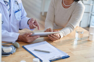 Healthcare professional discussing medical records with a senior patient during mental health treatment in Duluth, GA at Emerge Healing Centers.