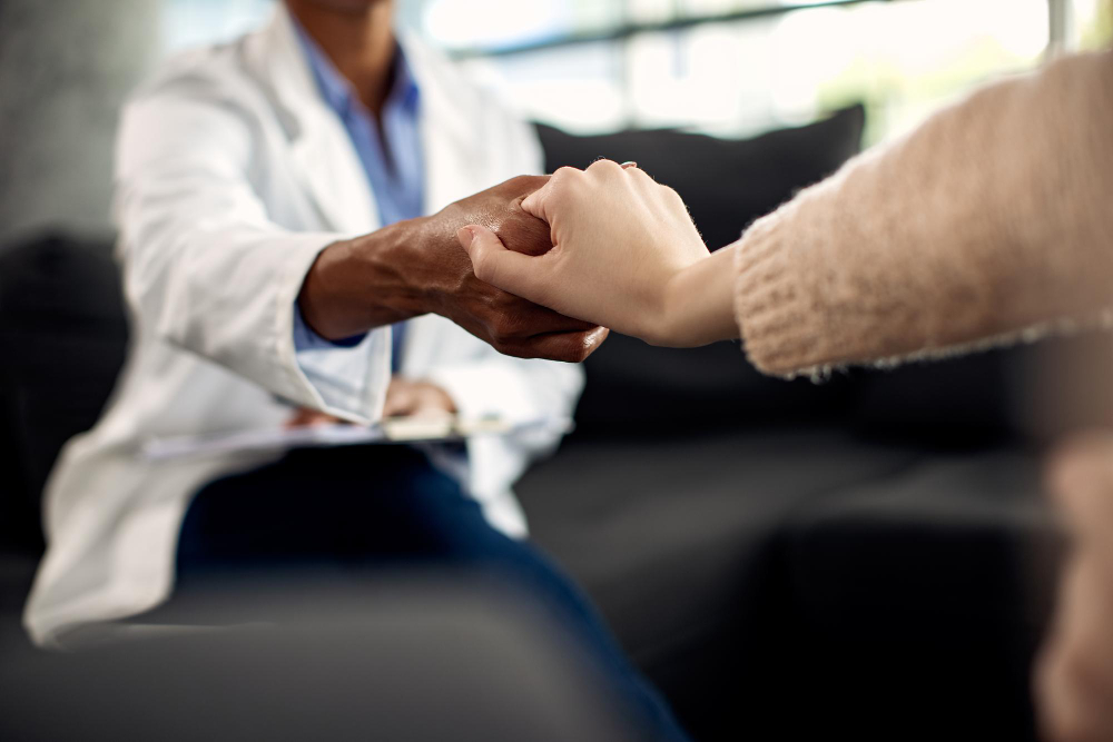 Psychotherapist holding a patient's hands during a counseling session at a Duluth rehab at Emerge Healing Centers.
